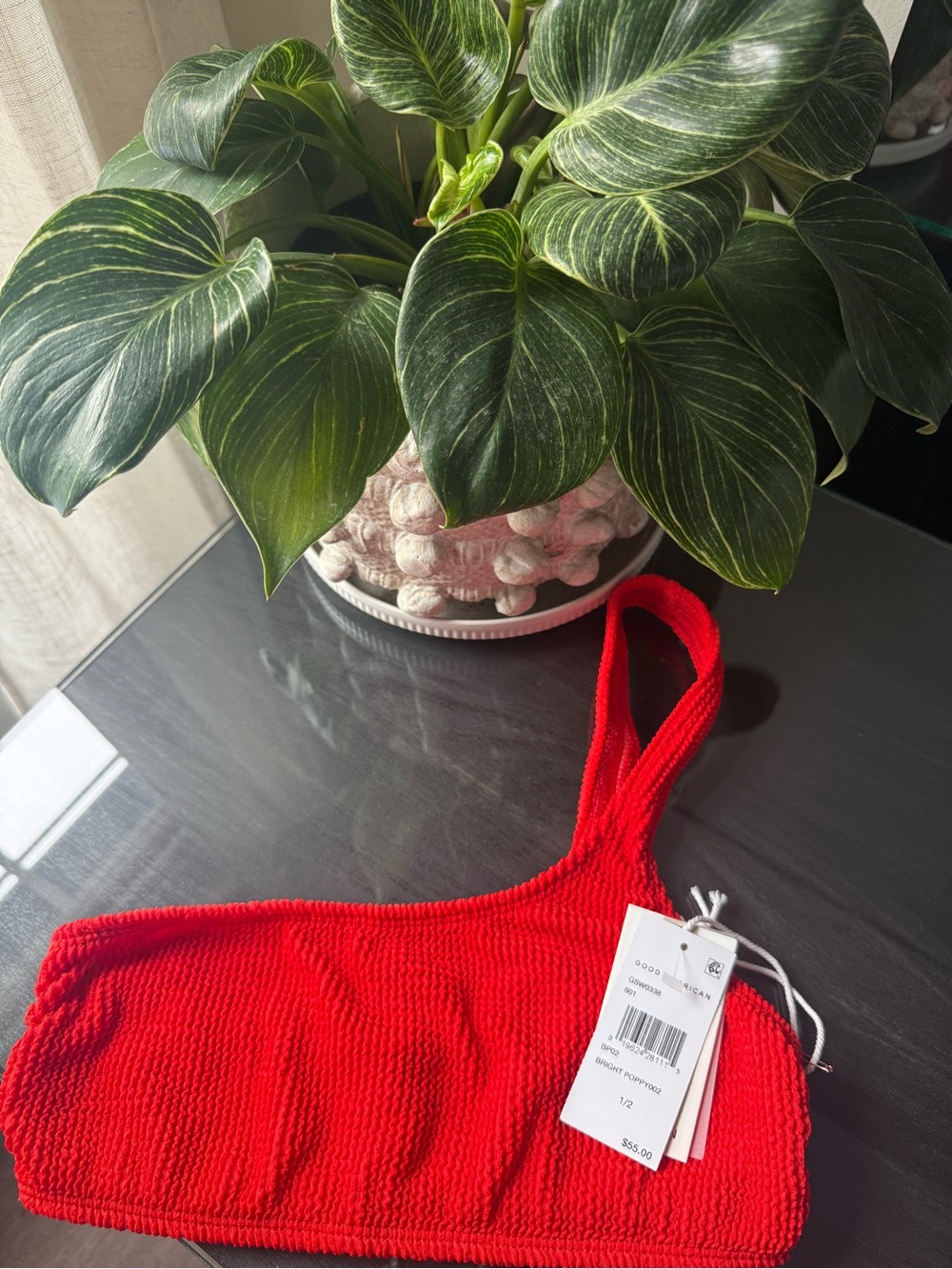 This is the Good American always fits swim top in color bright poppy. No padding